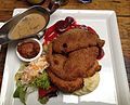 Schnitzel platter consisting of veal, pork, and chicken schnitzels, served with mashed potatoes, beetroot, mushroom cream sauce and side salad