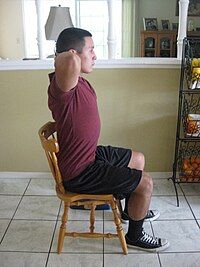 During exhalation, the patient will bend forward bringing the elbows together.