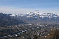 View of Triesenberg looking downstream at the municipality of Schaan in Liechtenstein over the Alpine Rhine to the municipalities of Buchs SG, Grabs and Gams SG and the snow-covered mountains of the Alpstein.