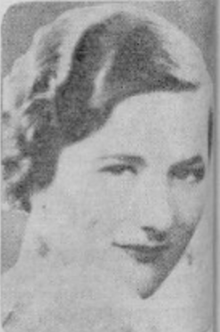 A white woman with hair in marcelled waves, glancing over one shoulder