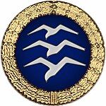 Badge: on a blue disc, silhouette of three white birds stacked in flight, the whole surrounded by a gold wreath