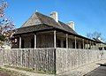 View of typical stockade fence; also view of side and front of house