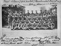 Group portrait of 38 men in military uniforms with peaked caps