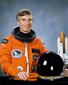 Ulf Merbold wearing an orange spacesuit