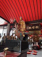 Statue of Amitabha riding on a peacock at the centre and the Thousand-armed Guanyin at the rear of the Five Hundred Arhat Hall of Baoguang Temple in Chengdu, Sichuan province, China