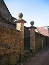 A pair of stone gate piers with ball finials