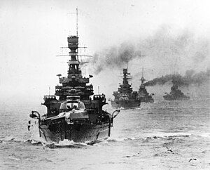 A formidable line of warships with big guns heads straight toward you, trailing smoke