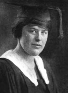 A young white woman wearing academic cap and gown