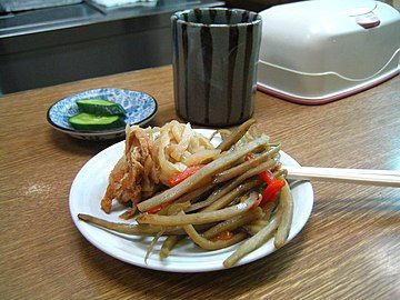 A Japanese appetizer, kinpira gobō, consisting of sauteed gobō (greater burdock root) and carrot, with a side of sautéed dried daikon