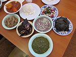 Clockwise from bottom: squid luau, pipikaula shortribs, kalua pig, tripe stew, rice, opihi poke, laulau, and poi in the center