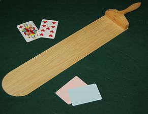 A baccarat palette and cards on a casino gambling table.