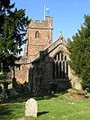 Stone building with arched windows and square tower.