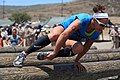 Jasmine Dever hurdles over a set of wooden logs during event 3.