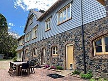 Clad in wood, painted blue, stonework on the lower half