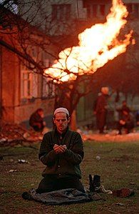 A Chechen man prays during the Battle for Grozny