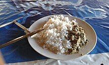 A white plate full of white rice and matapa