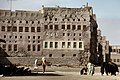 This photograph, taken in 1975, depicts one of the larger houses in Qatif Castle, with residents walking around it.