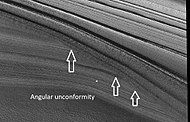 Close view of layers in northern ice cap, as seen by HiRISE under HiWish program. Arrows point to an angular unconformity.