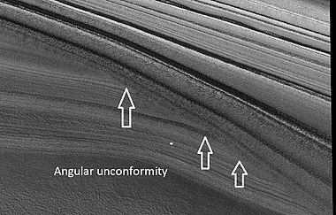 Close view of layers in northern ice cap, as seen by HiRISE under HiWish program. Arrows point to an angular unconformity.