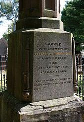 Close up photograph of a sandstone gravestone with oblique lighting to highlight the inscription