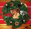 Advent wreath with one rose candle and three purple candles, all lit