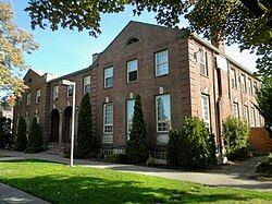 A two story brick building with keystones over the first floor windows.