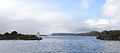 Hell's Gates, the entrance to Macquarie Harbour, viewed from outside. Entrance Island is on the left. Bonnet Island lighthouse is visible in the distance.