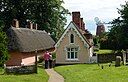 ☎∈ Almshouses at the parish church of St John in Thaxted, with the sailless John Webb's Windmill in the background, in July 2012.