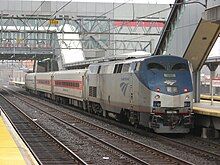 A train with a diesel locomotive at a large train station