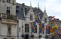 A town hall in Flanders displaying heraldic banners