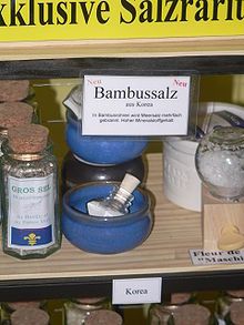 A small glass vial of salt on a store shelf, under a sign reading "Bambussalz".