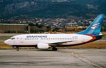 Boeing 737-700 with a white body and blue vertical stabilizer