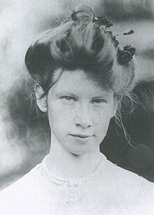 Woman wearing a white dress with her hair in a large bun