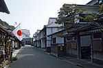 Street lined with wooden houses with white walls.