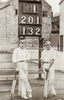 Lionel Palairet and Herbie Hewett posing in front of the scoreboard