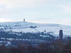 Winter outdoor scene, showing town in foreground with snowy moors with the tower on the horizon