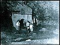 Older photo of family getting water from the spring