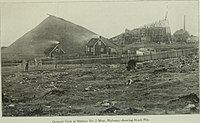 Above-ground portion of the No. 2 Mine with a huge pile of mined ore (early 20th century) next to it. Such heaps were built in winter, as shipping was then at a standstill.[39]