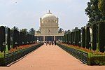 A white Islamic mausoleum in a garden