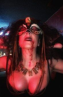 Z dressed in an elaborate mask with fake blood on her chest