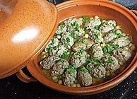 Traditional Algerian tajine mtewem made with white sauce and served in a tajine pot