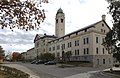 Autumn photograph of Grant Hall at Fort Leavenworth, with its clocktower rising above its porticoed main entrance.