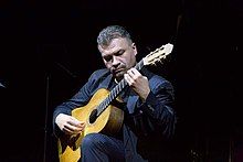 Pusztai holding a guitar