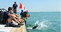  A diver enters the water watched by the supervisor and standby diver, with warning flags flying