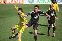 Eddie Gaven competes for a header with Marc Burch during a match at Columbus Crew Stadium