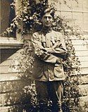 =A young man in vintage Boy Scout uniform, arms folded