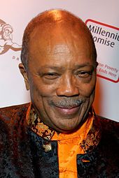 Head shot of a man with a mustache wearing a decorative black and yellow outfit