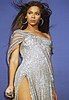 Beyonce Knowles in silver sequined dress with hair flying in the air