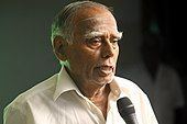 Photograph of an old man in white shirt.