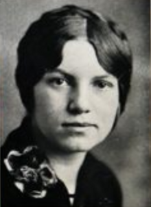 A young white woman with hair braided across the crown